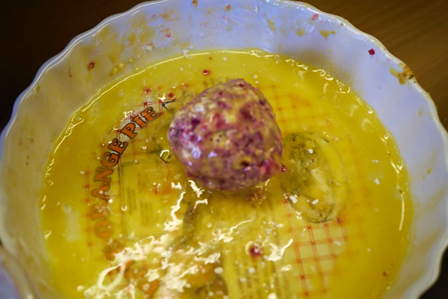 Applying the egg to the balls to allow the breadcrumbs to stick