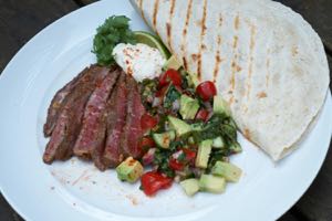 Spicy Flat Iron Steak servered with salad and bread